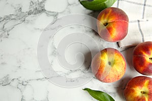 Fresh peaches, leaves and fabric on marble table. Space for text