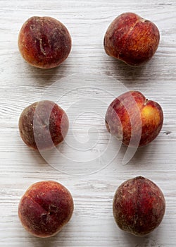 Fresh peaches on white wooden background, top view. Overhead, from above. Close-up