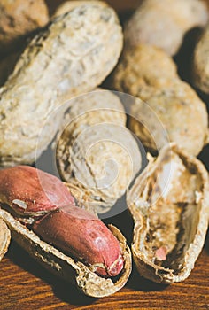 Fresh peanuts in shel and peeled without shell on the wooden table background close up photo