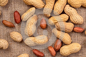 Fresh peanuts in shell on burlap, top view