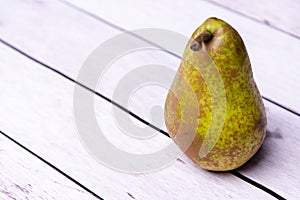 Fresh pear lying on a wooden white table