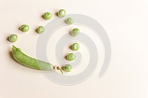 Fresh peas isolated on yelow background.Top view, selected focus. Heart shape