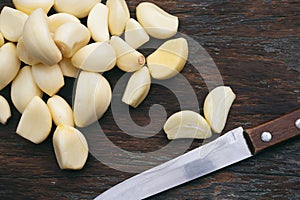 Fresh Peeled Garlic Cloves on old wooden background photo