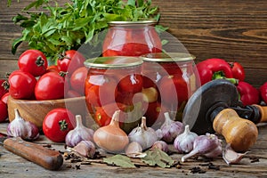 Fresh and pickles ripe tomatoes and sweet red bell peppers. Jars of canned vegetables. Homemade vegetable marinating still life