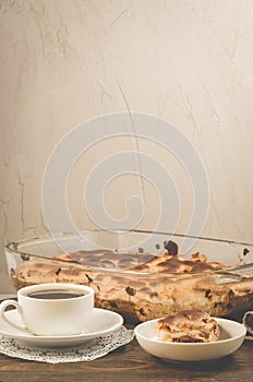 Fresh pie and cup of fragrant black coffee/fresh pie and cup of black coffee on a wooden table and stone background with copy