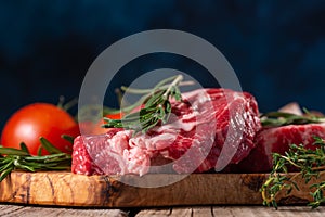 Fresh piece of beef steak with rosemary on the background of the ingredients.Recipe book, dishes with meat .Advertising butcher