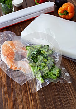 Fresh pieces of broccoli in a vacuum bag and a piece of red fish