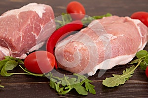 Fresh pieces pork ready to Cook on a wooden board in the rustic kitchen