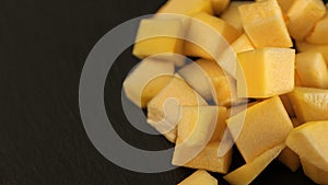 Fresh pineapple cube slices on black background. Pineapple chunks close up