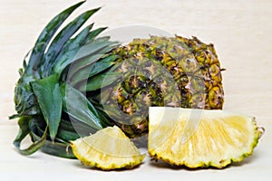 Fresh pineapple with slices on wood