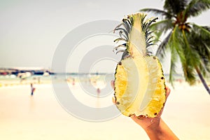 Fresh pineapple with in woman hands on tropical beach - vacation in summer