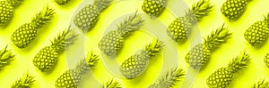 Fresh pineapples on trendy neon yellow color background. Top View. Pop art design, creative concept. Copy Space. Bright pineapple