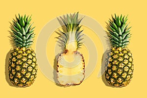 Fresh pineapples on yellow background. Creative suumer concept