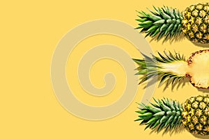 Fresh pineapples on yellow background. Creative suumer concept