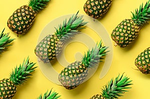 Fresh pineapples on yellow background. Top View. Pop art design, creative concept. Copy Space. Bright pineapple pattern