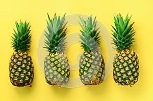 Fresh pineapples on yellow background. Top View. Pop art design, creative concept. Copy Space. Bright pineapple pattern