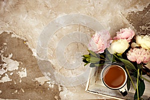 Fresh pink peonies flowers on aged wooden background. Flat lay. Top view with copy space. Toned image.