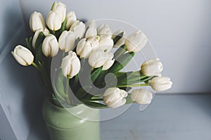 Fresh pink tulip flowers bouquet on shelf in front of stone wall. View with copy space