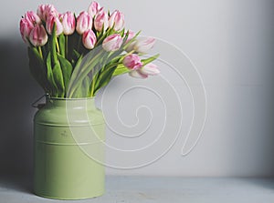 Fresh pink tulip flowers bouquet on shelf in front of stone wall. View with copy space