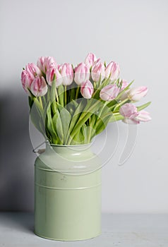 Fresh pink tulip flowers bouquet on shelf in front of stone wall. View with copy space