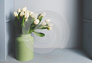 Fresh pink tulip flowers bouquet on shelf in front of stone wall. View with copy space