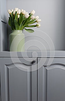 Fresh pink tulip flowers bouquet on shelf in front of stone wall. View with copy space