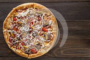 Fresh pizza with tomato sauce, black olives, mozzarella cheese, ham on wooden table closeup. Space for text or copy space. Pizza