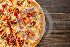 Fresh pizza with tomato sauce, black olives, mozzarella cheese, ham on wooden table closeup. Space for text or copy space. Pizza