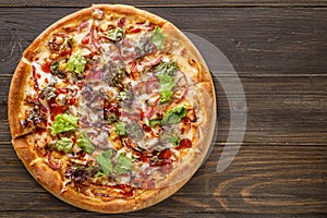 Fresh pizza with tomato sauce, black olives, mozzarella cheese, ham on wooden table closeup. Space for text or copy space. Pizza