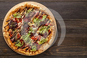 Fresh pizza with tomato sauce, black olives, mozzarella cheese, ham on wooden table closeup. Space for text or copy space. Pizza