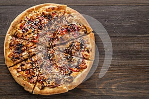 Fresh pizza with tomato sauce, black olives, mozzarella cheese, ham on wooden table closeup. Space for text or copy space. Pizza