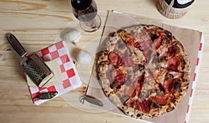 Fresh Pizza on Wooden Table at Restaurant With Bottle of Chianti Wine in Background