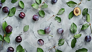 Fresh plums with leaves scattered on textured background