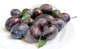 Fresh plums on white plate.