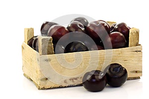 Fresh plums in a wooden crate