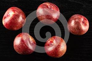Fresh pluot interspecific plums on black wood