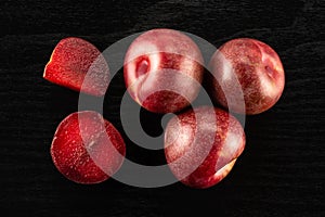 Fresh pluot interspecific plums on black wood