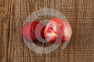 Fresh pluot interspecific plums on brown wood