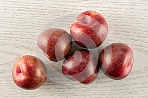 Fresh pluot interspecific plums on grey wood