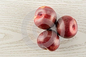 Fresh pluot interspecific plums on grey wood