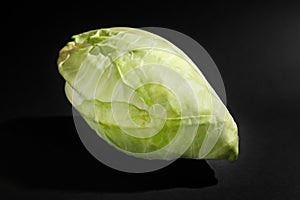 Fresh pointed cabbage on dark background