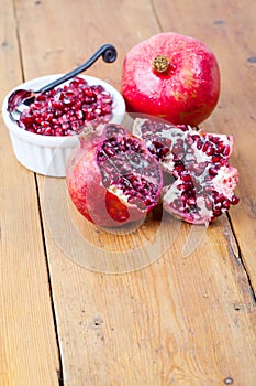 Fresh pomegranate fruit and pips in white bowl