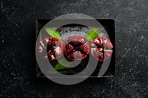 Fresh pomegranate fruits on a metal tray.