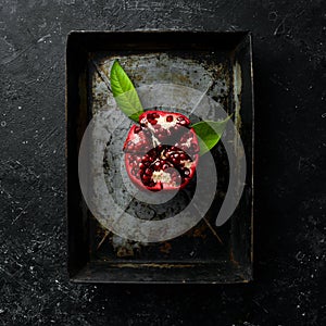 Fresh pomegranate fruits on a metal tray.