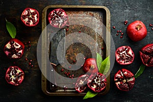 Fresh pomegranate fruits on a metal tray.
