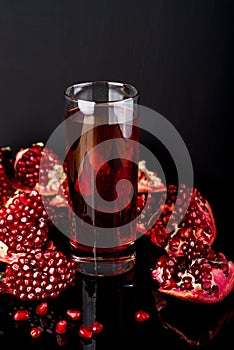 Fresh pomegranate juice. Pomegranate. On a black background. Copy space.