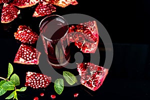 Fresh pomegranate juice. Pomegranate. On a black wooden background. Top view. Copy space.