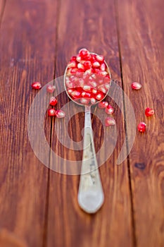 Fresh pomegranate seeds, lie on a wooden