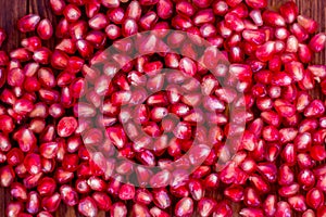 Fresh pomegranate seeds, lie on a wooden