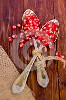 Fresh pomegranate seeds, lie on a wooden